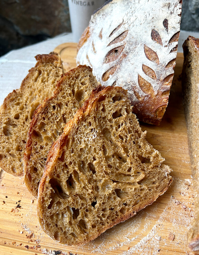 3 slices of honey molasses sourdough bread on a wood board