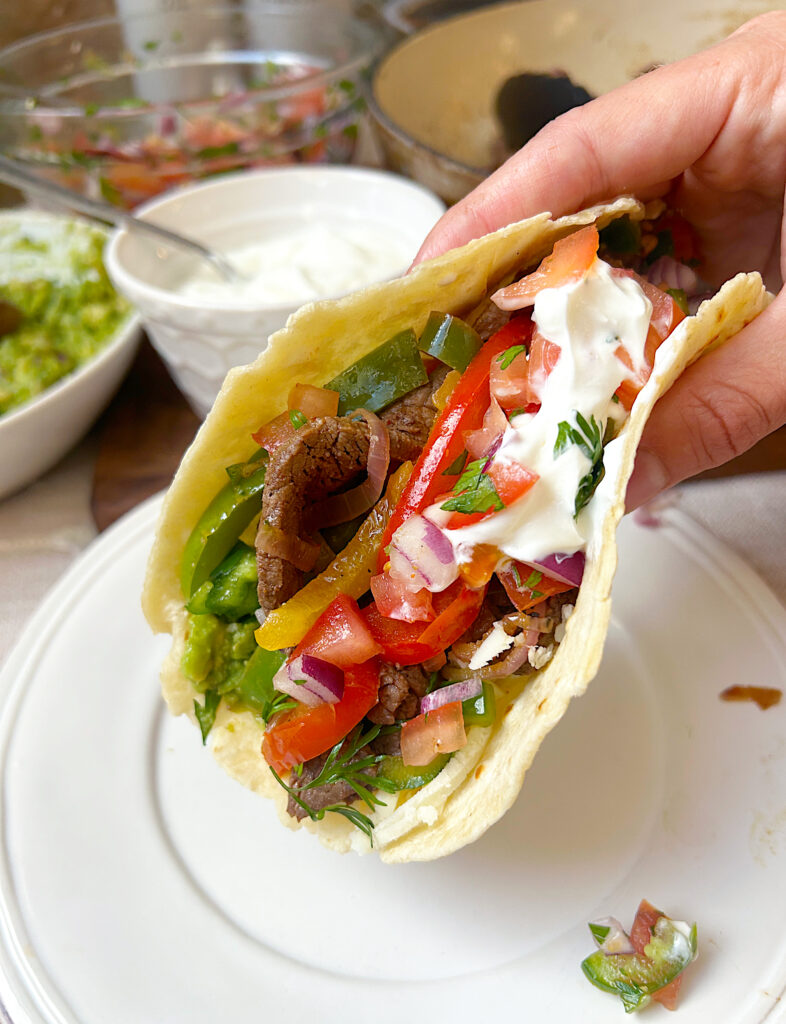 a soft fajita full of venison steak, peppers and onions