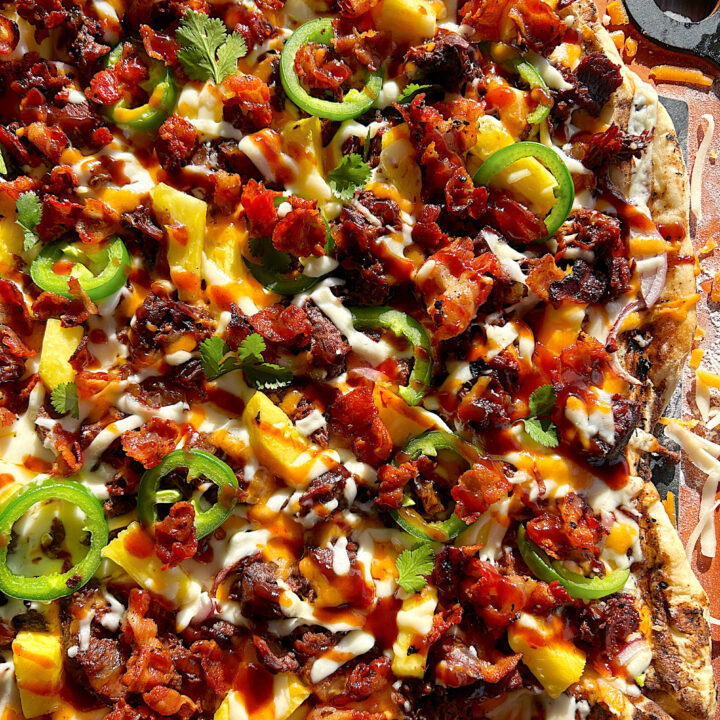 a flatbread pizza with bbq venison, pineapple, cheese, and jalapeños