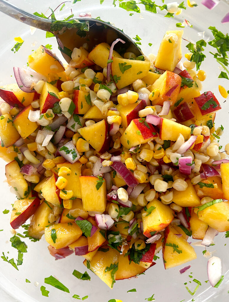 a glass bowl of roasted corn and peach salsa
