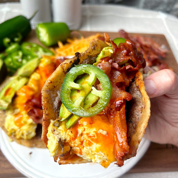 a breakfast taco with sausage, eggs, cheese, bacon and jalapeños