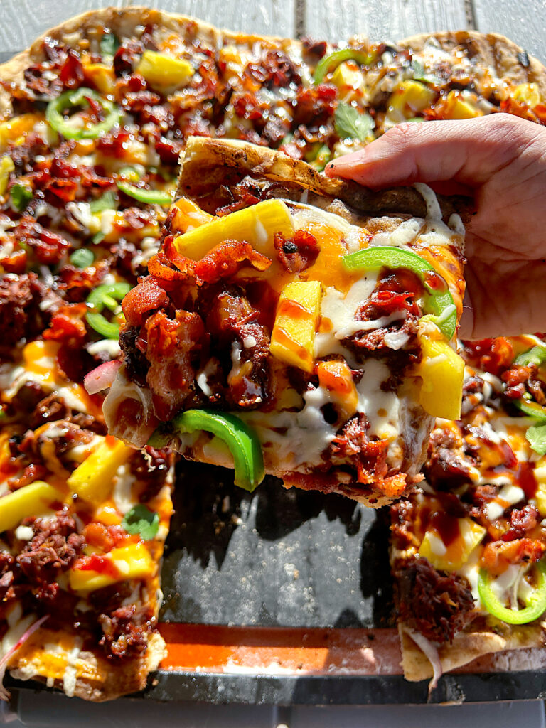 a sliced of bbq pineapple pizza