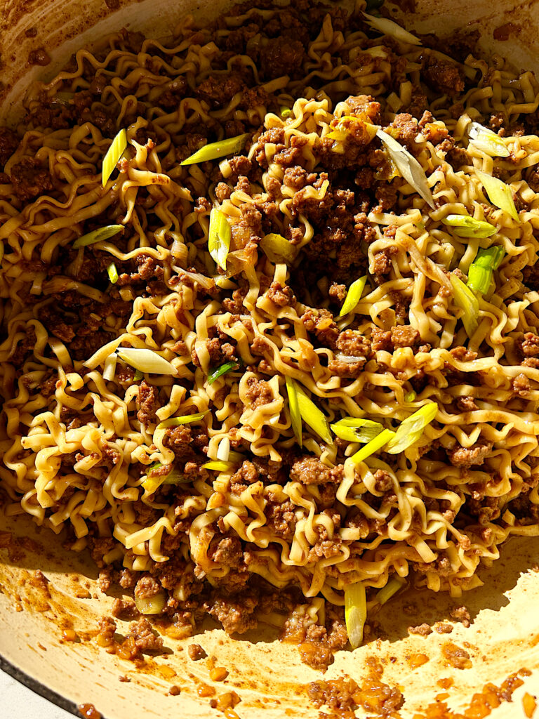a skillet of sweet and salty noodles with ground meat and green onions