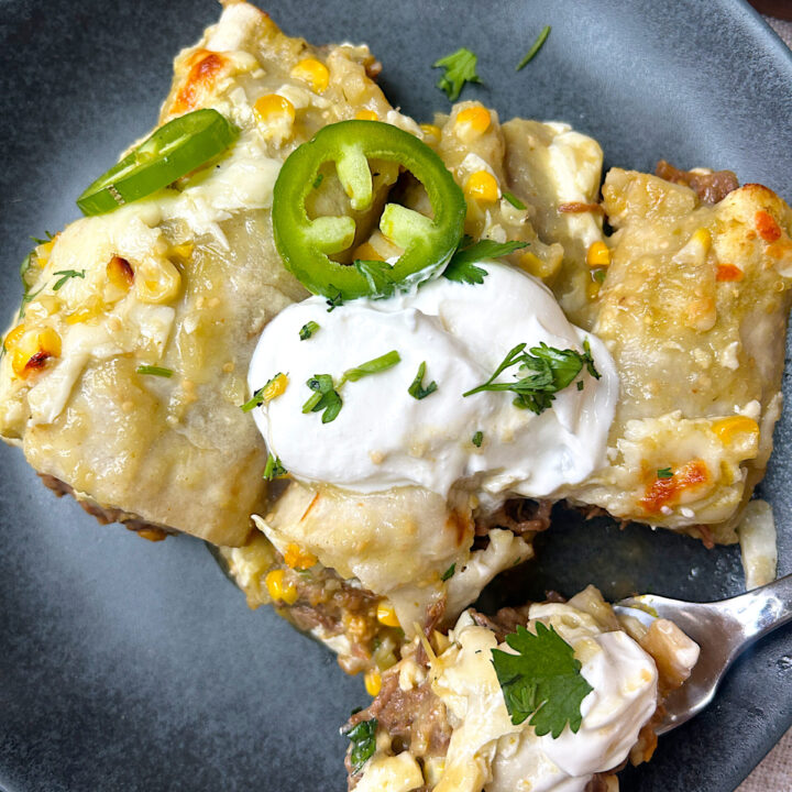a blue plate with venison enchiladas with green Chile sauce