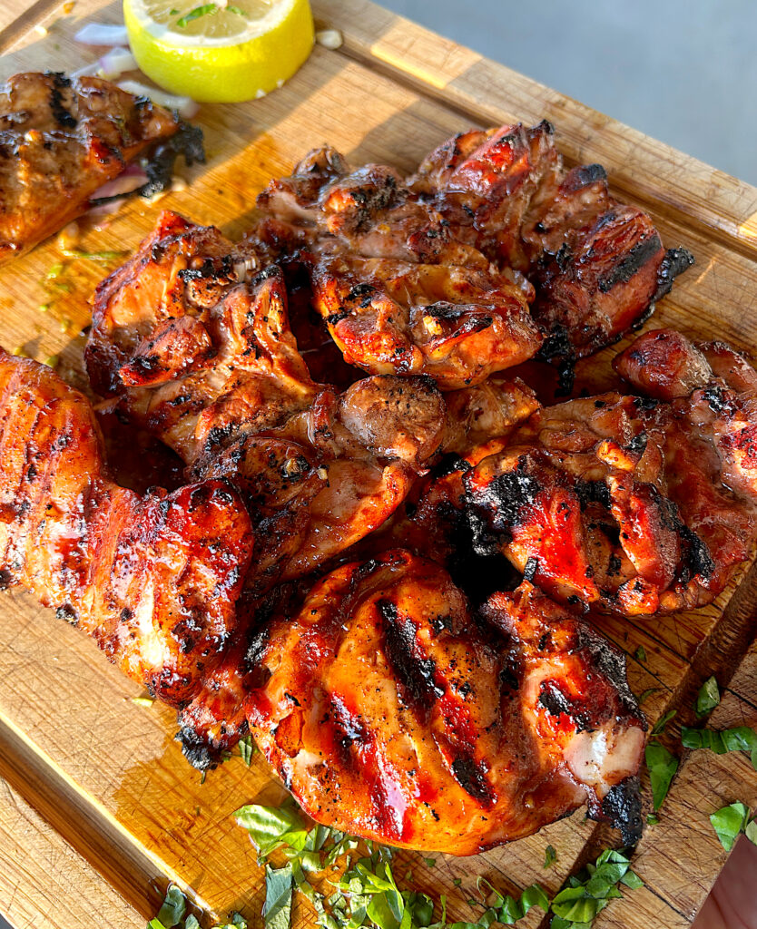 s wood board of grilled chicken thighs