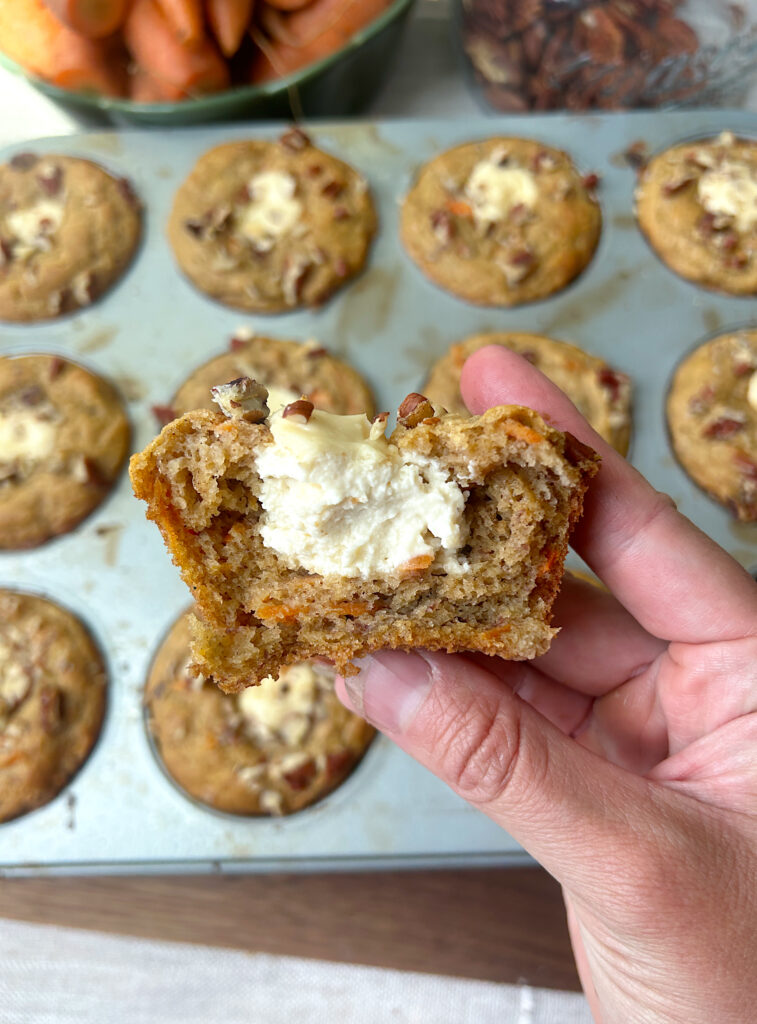half of a muffin stuffed with cream cheese