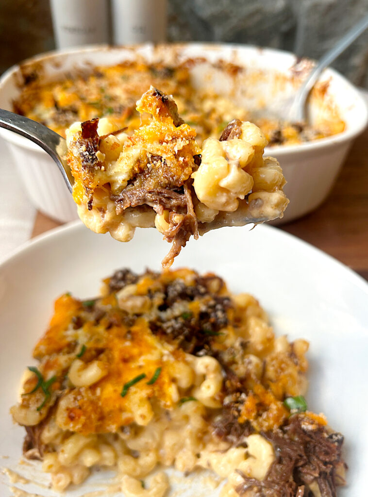 a spoonful of macaroni and cheese with shredded bbq meat
