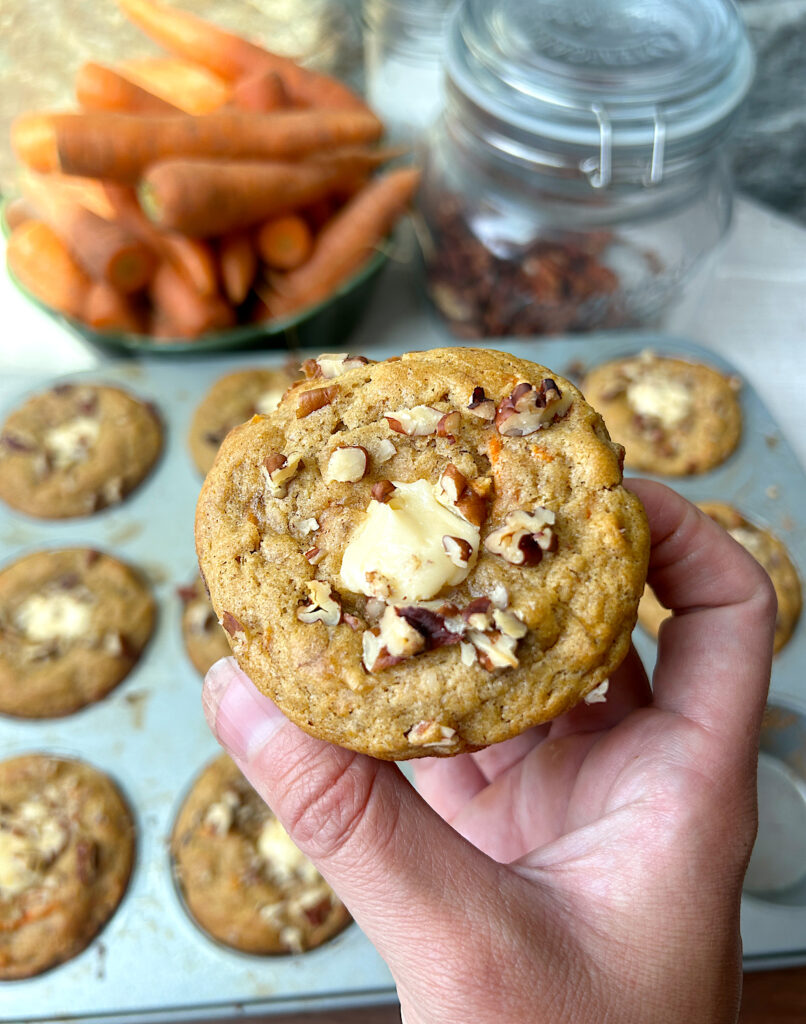 a banana muffin stuffed with cream cheese with pecans on top