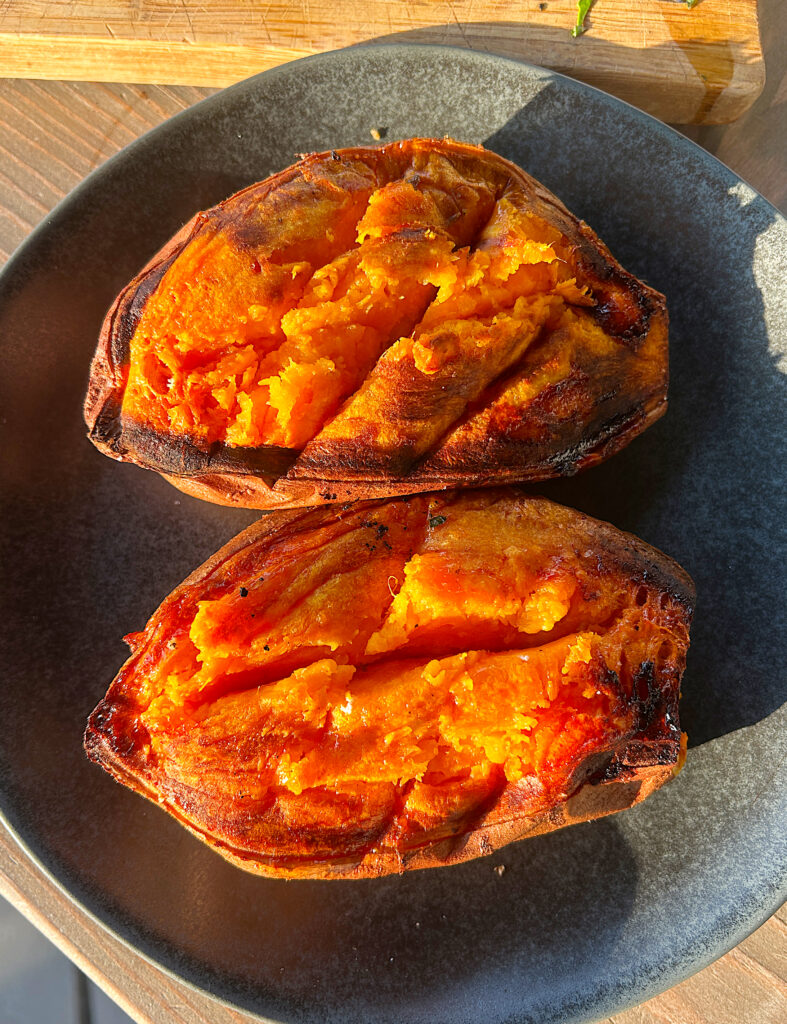 a plate with a roasted sweet potato cut in half