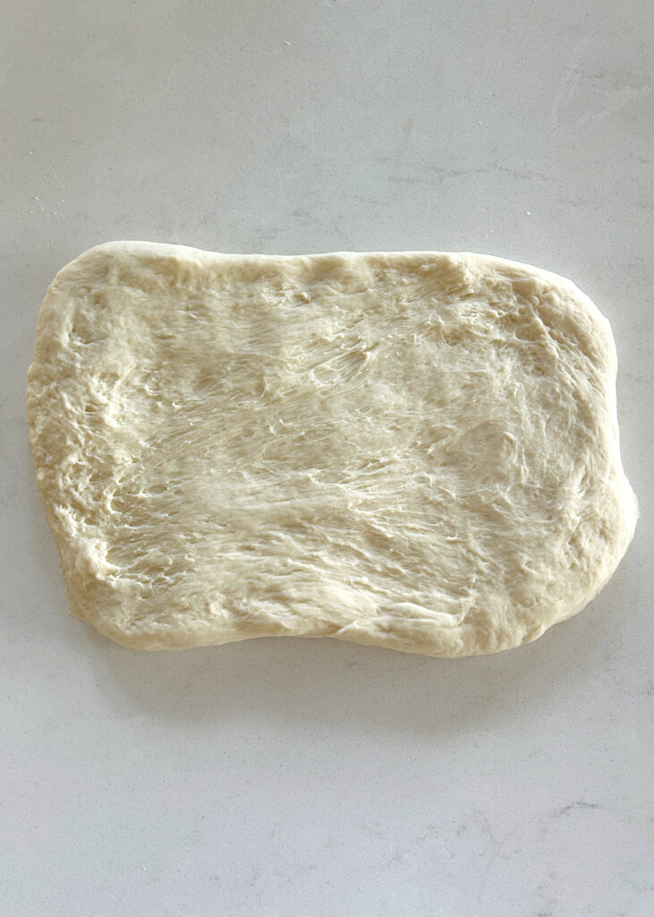 a rectangle of dough on a white counter