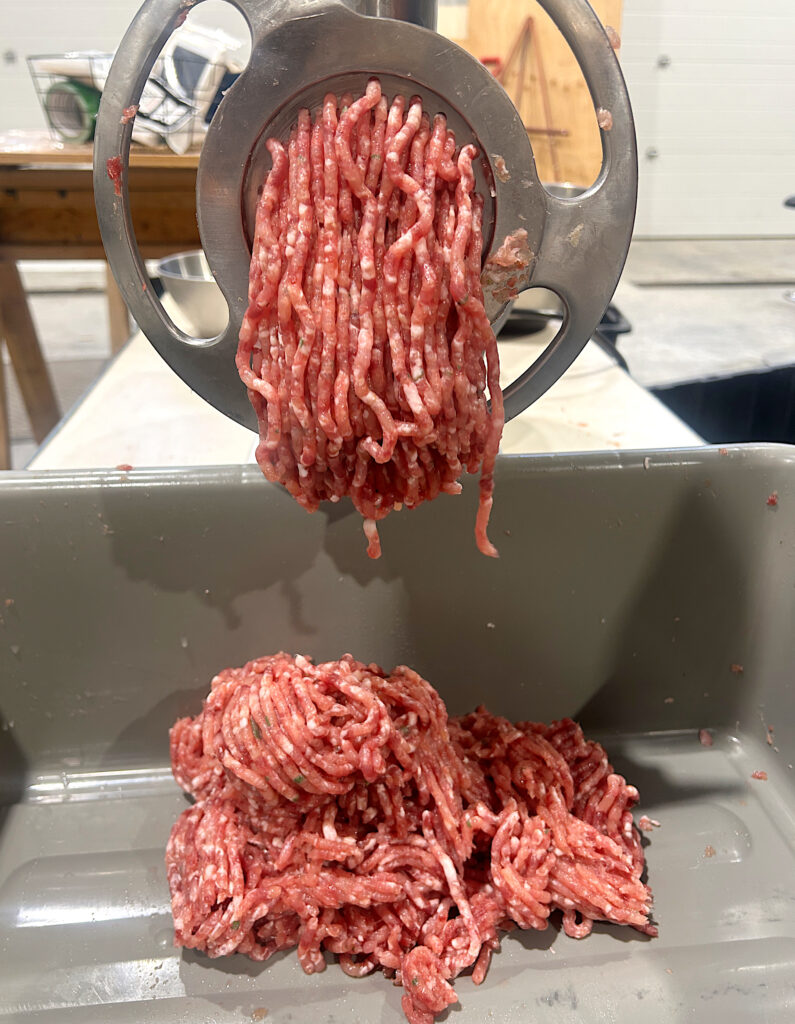 fine ground turkey meat coming out of a grinder