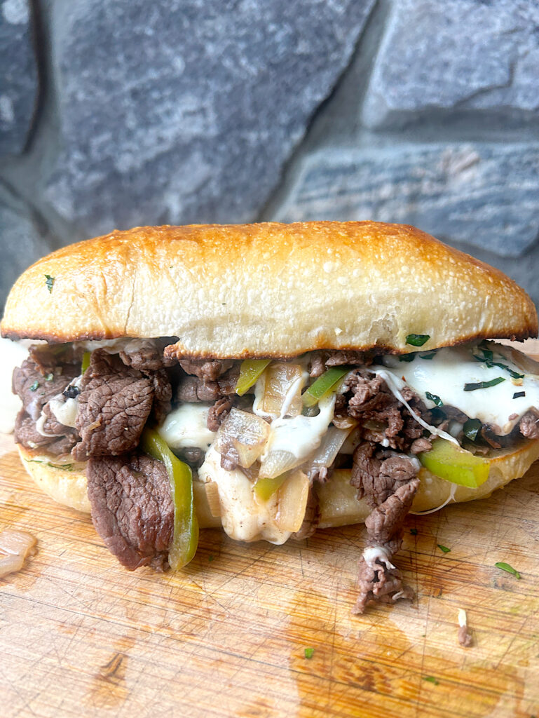 a Philly cheese steak sandwich on a sourdough hoagie bun
