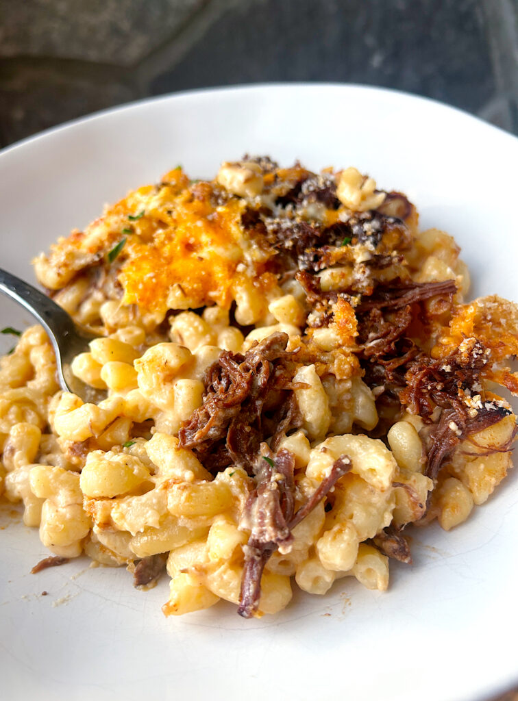 a white bowl of Mac n; cheese with bbq meat