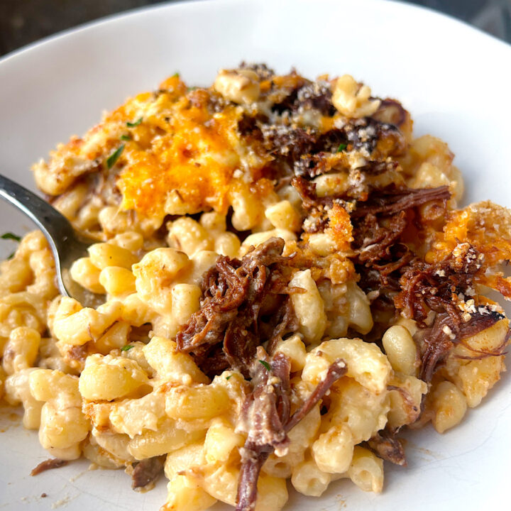 a white bowl of Mac n; cheese with bbq meat