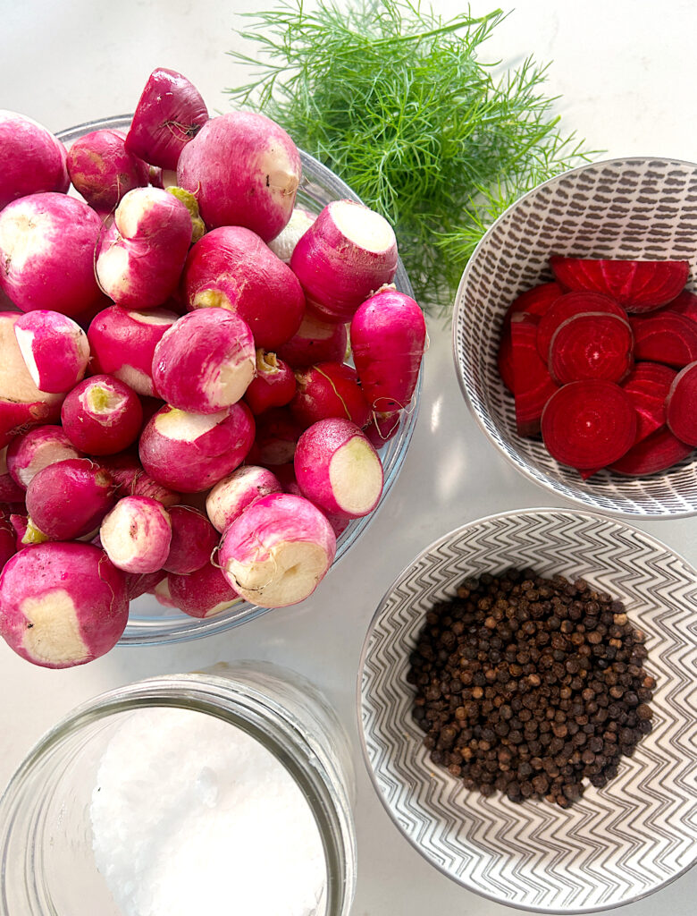 a bowl of radishes with dill, beets, peppercorn and slat on the salt