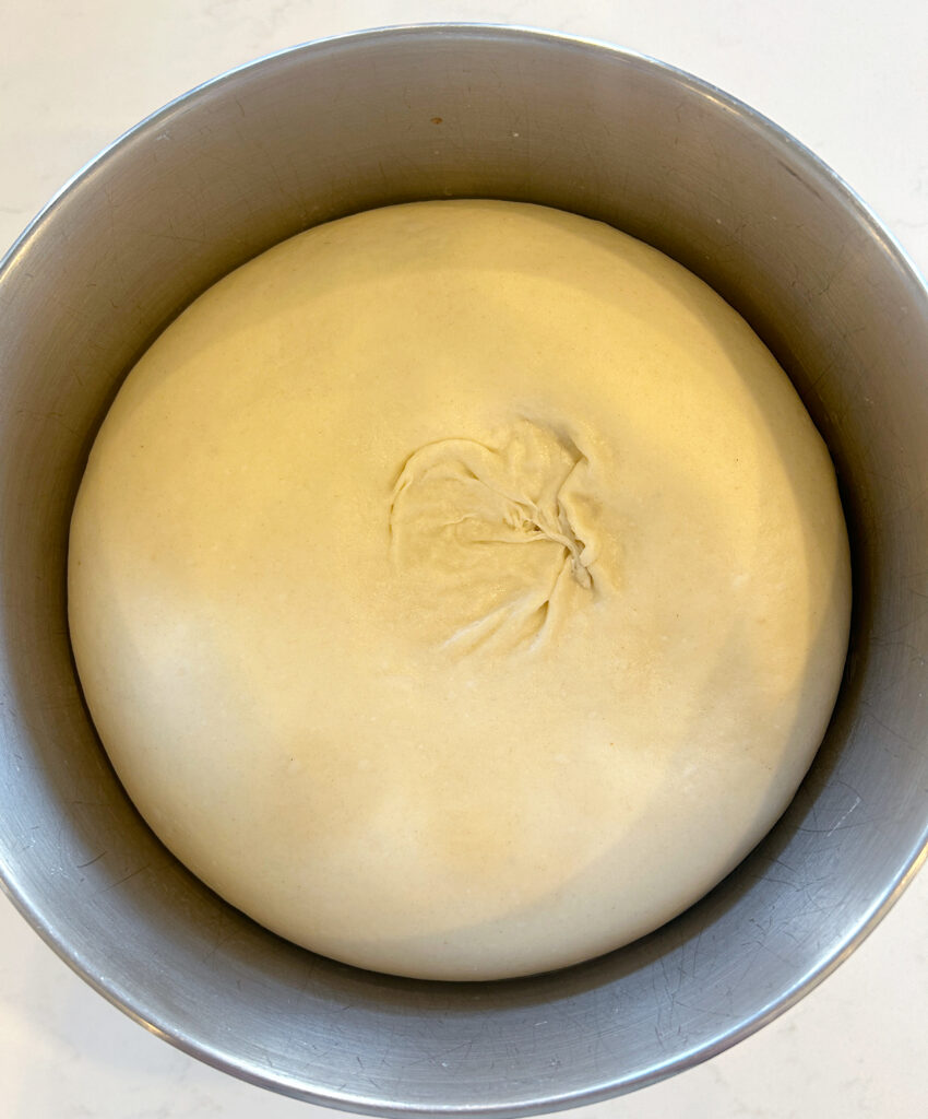 a bowl of risen soft pretzel dough