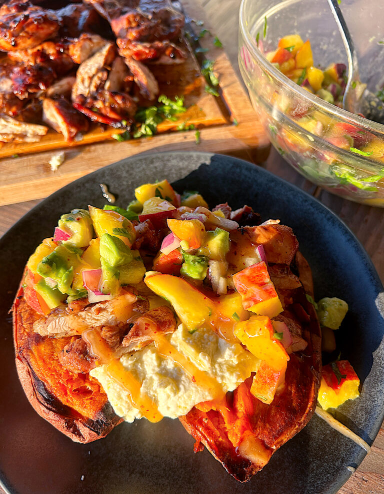 a baked sweet potato with whipped feta, chicken and peach salsa