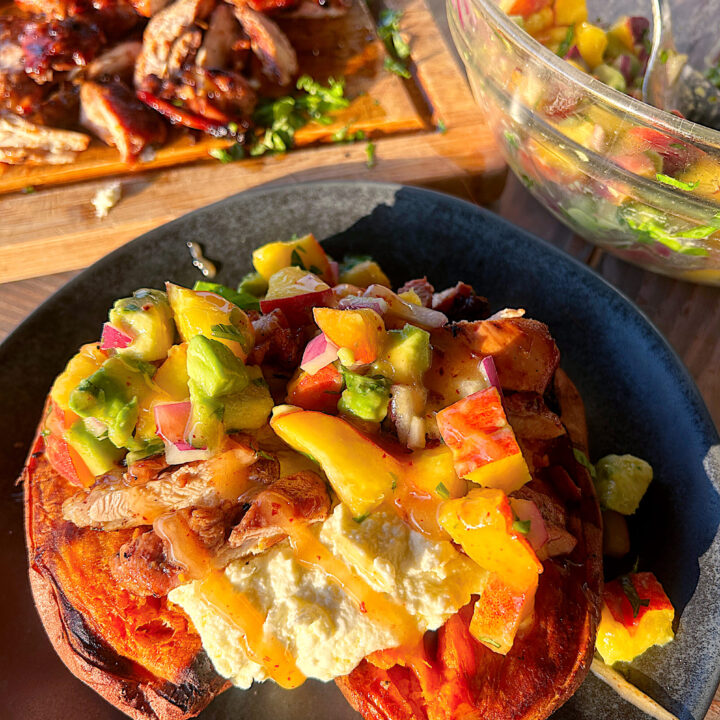 a baked sweet potato with whipped feta, chicken and peach salsa
