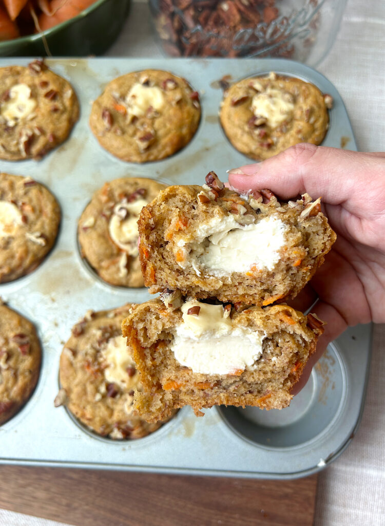 a carrot and banana muffin broken in half filled with cream cheese