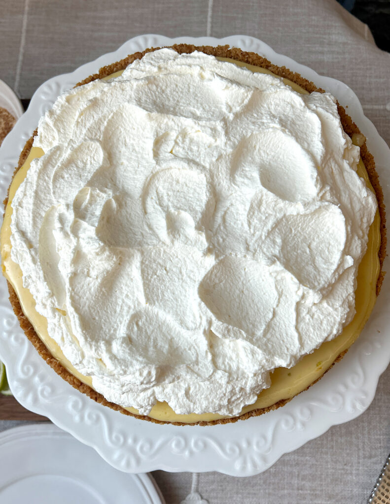 a pie with a graham cracker crust and whipped cream topping