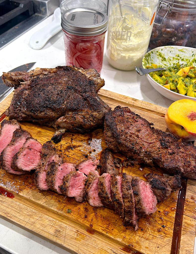 a wood board with sliced steak 