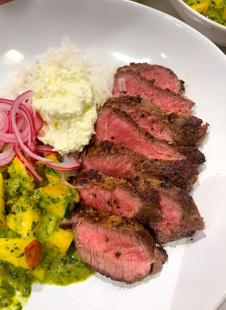 sliced medium rare steak in a white bowl