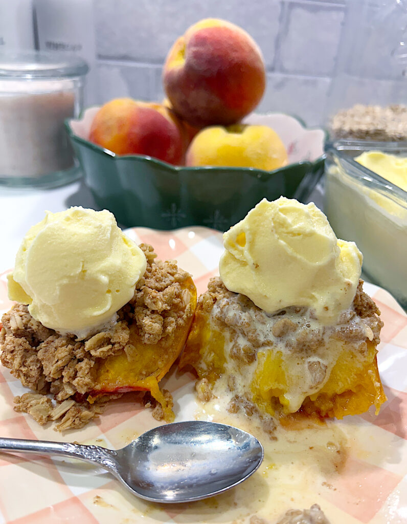 a peach half topped with buttery crumble and honey vanilla ice cream
