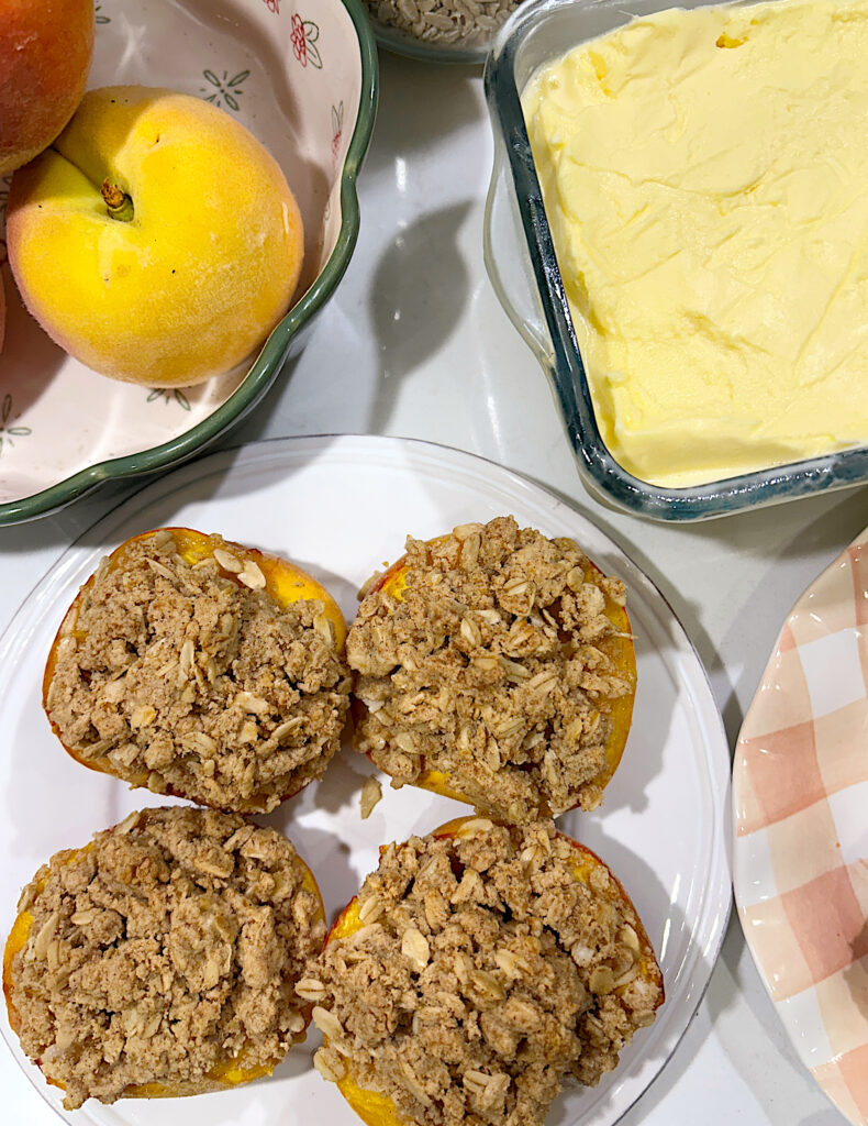 a white plate with baked peaches with crumple topping