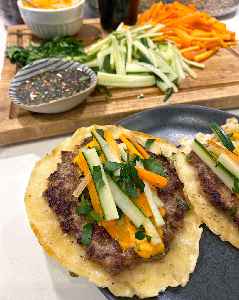 a smash taco with ground meat, fresh vegetables and spicy mayo