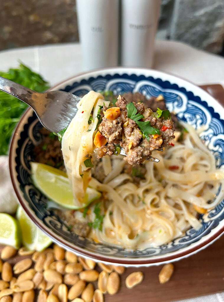 a fork full of curry rice noodles and ground meat