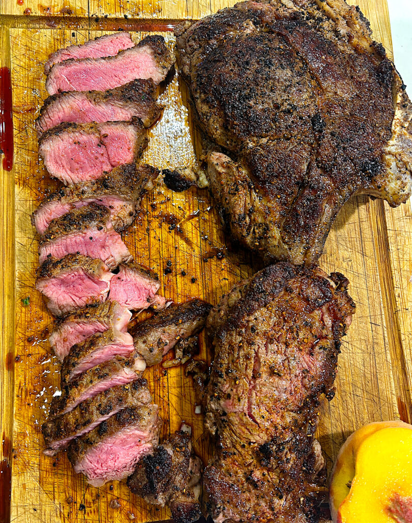 a wood board with sliced steak on top