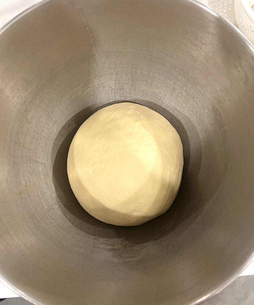 a stainless bowl with bread dough