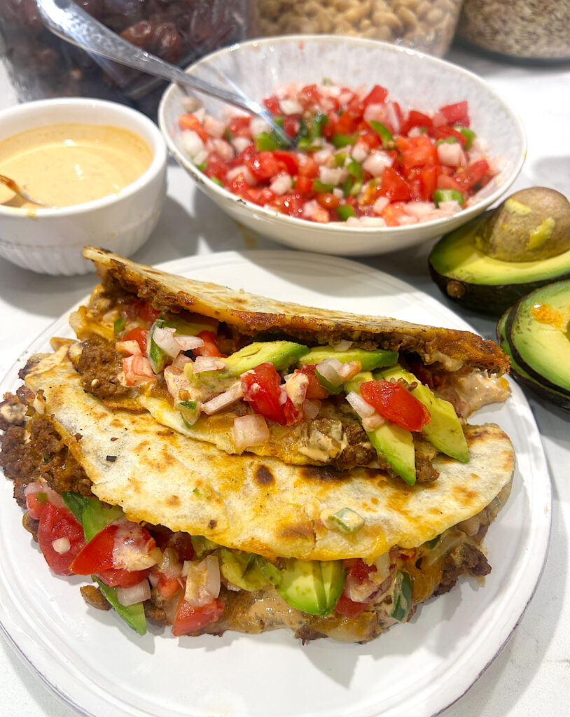 a white plate with two crispy tacos