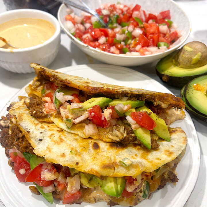 a white plate with two crispy tacos