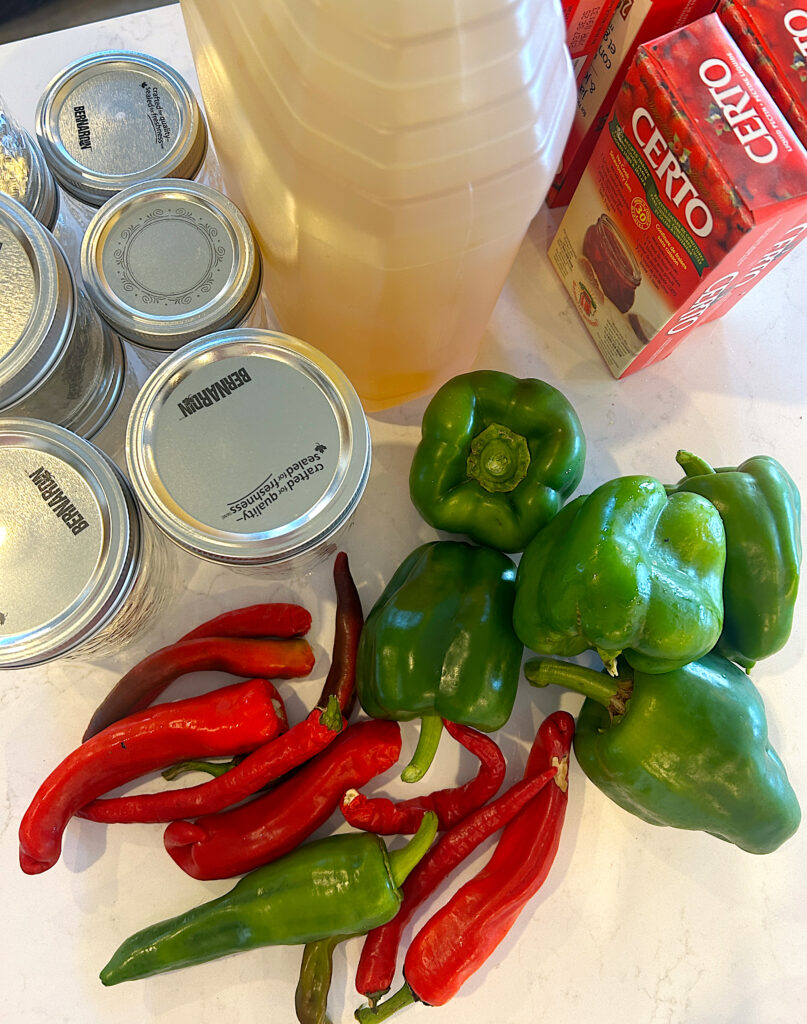 bell peppers, hot peppers and vinegar on a white counter