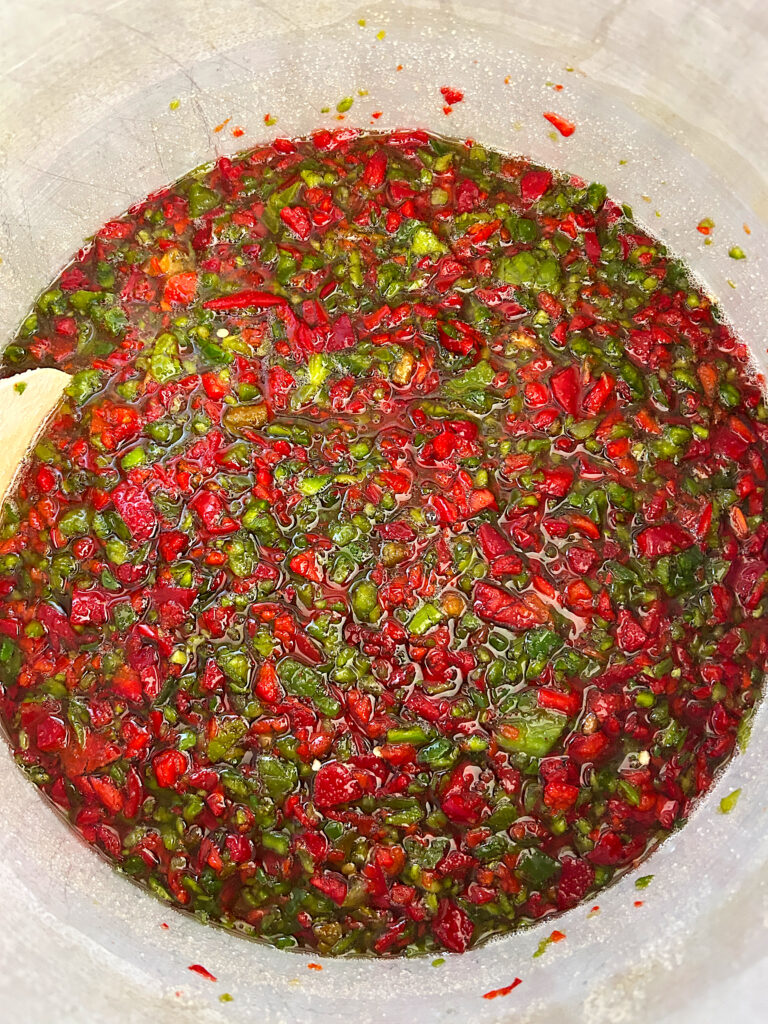 a large pot of diced red and green peppers in vinegar