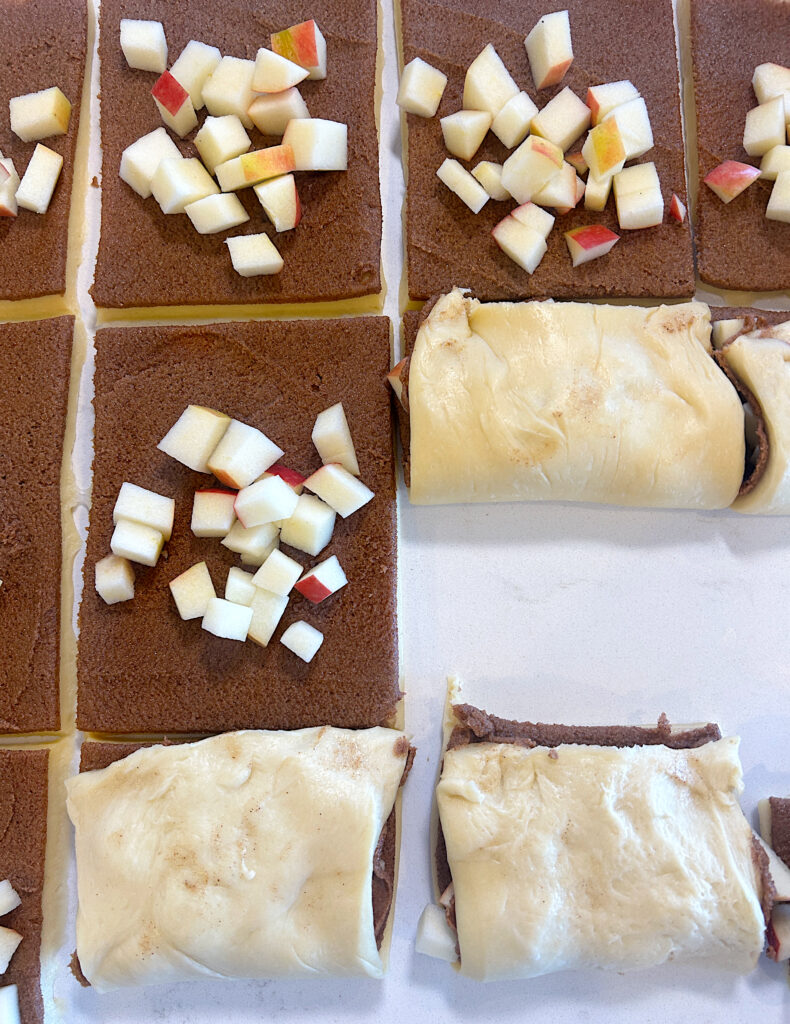 squares of bread dough with brown sugar filling and apple pieces