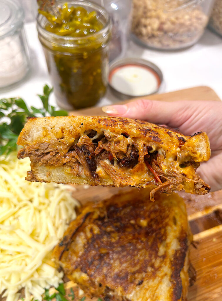 half a grilled cheese sandwich full of shredded venison meat