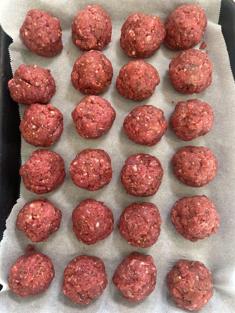 a tray of uncooked meatballs