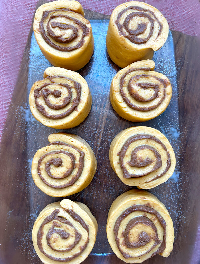 a glass baking dish of unbaked cinnamon buns