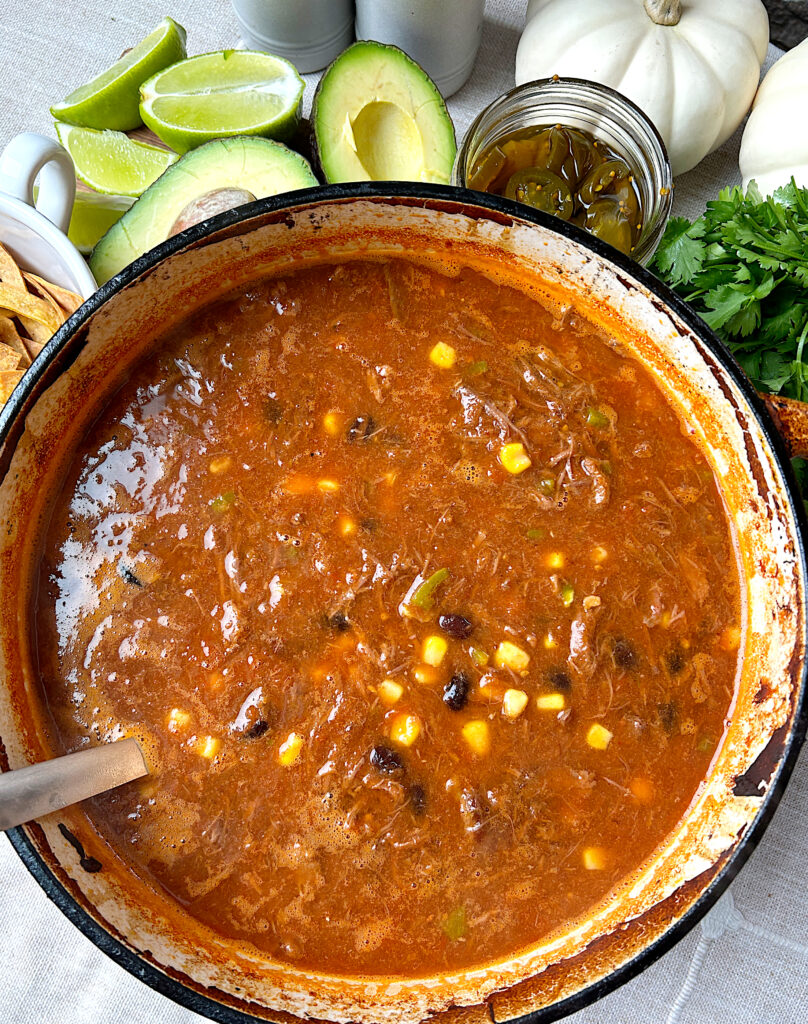 a pot of tortilla soup full of shredded venison, corn and black beans