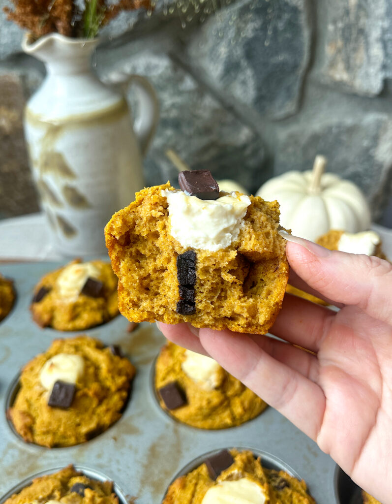 a pumpkin and cream cheese muffin broken in half