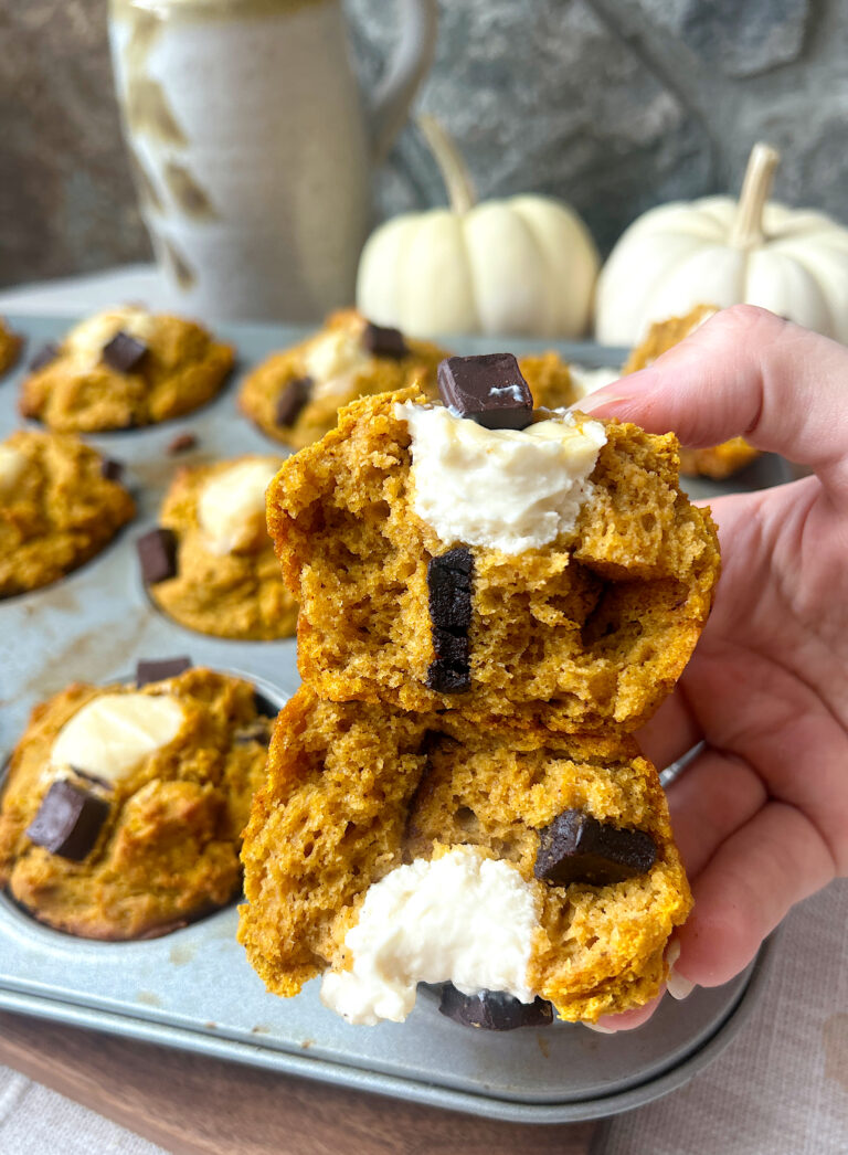 a pumpkin muffin stuffed with cream cheese broken in half