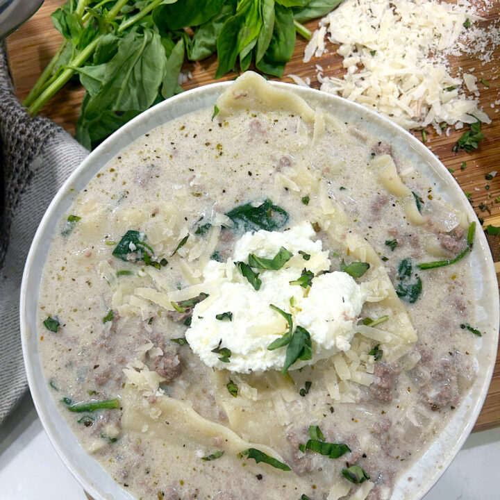 a bowl of creamy soup with noodles and ground venison and ricotta cheese on top